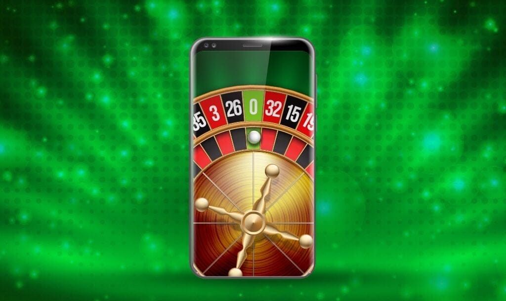 An illustration of a smartphone with a roulette wheel on it. The roulette ball is sitting in the green zero pocket on the roulette wheel. There is a background consisting of different green hues behind the smartphone.