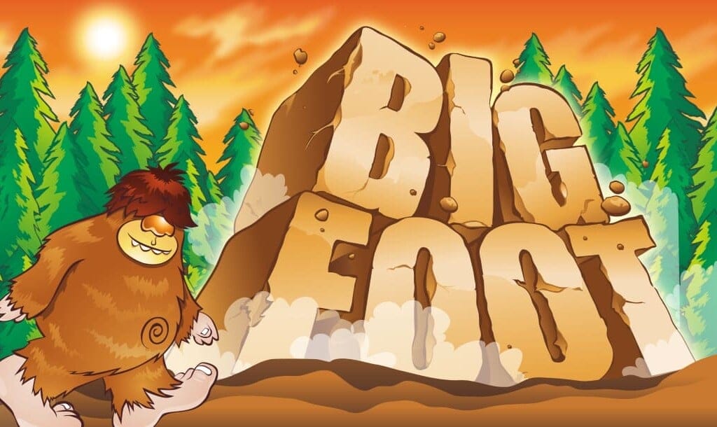 The Big Foot online slot game banner in a cartoon style. The game title is presented in large letters that resemble blocks of rock. There are pine trees in the background and Bigfoot is walking in from the left.