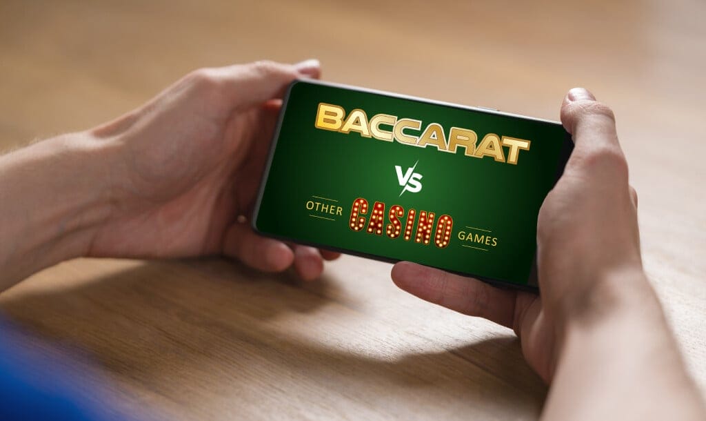 A person holding a smartphone displaying a green screen with the text “Baccarat vs Other Casino Games” in bold, stylized fonts.