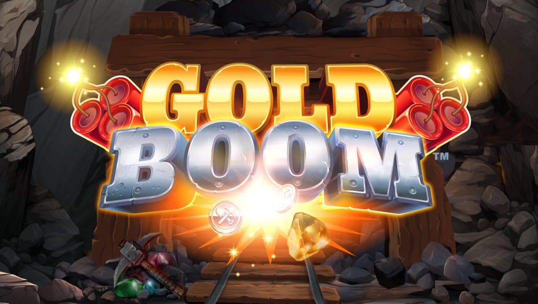 The Gold Boom logo features gold and silver letters with stacks of lit dynamite on either side. An explosion below the title sends a gold nugget and silver coins flying. The background features the entrance to a mine, with a cart track leading inward and a pickaxe on a pile of gemstones to the left.