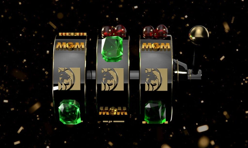 A sleek, black-and-gold slot machine reel featuring emerald gems and the MGM lion logo, set against a sparkling confetti background.